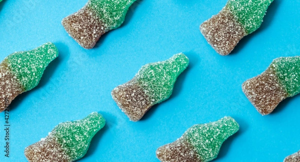 Fototapeta Sweets pattern.Cola candy jelly background isolated on blue background.Top view.