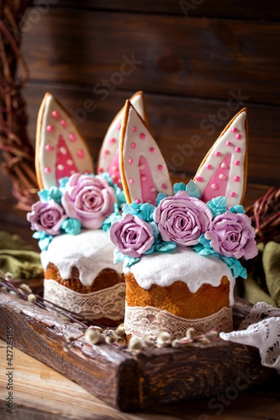 Fototapeta easter cake with rabbit ears made of gingerbread and meringue roses on a dark background