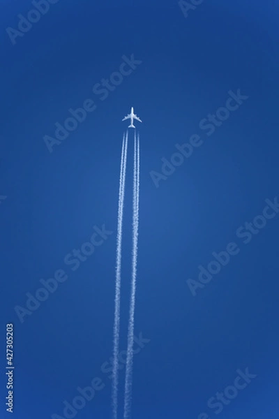 Obraz Jet trail from airplane travelling over clear blue sky