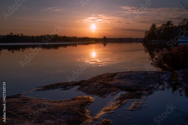 Fototapeta An early spring sunset over Lake Muskoka in the small cottage town of Gravenhurst, Ontario, reflecting in the water.