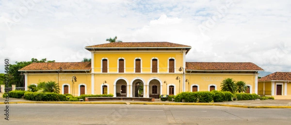 Fototapeta edificio colonial de dos pisos antiguo terminal de tren color amarilla con cielo blanco 