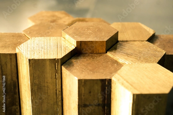 Fototapeta Hexagon made of brass sawn into blanks for further processing on a metalworking machine. Metal cutting in production. 