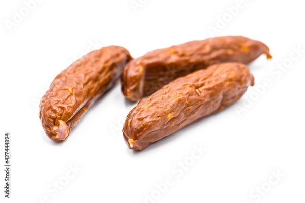 Fototapeta Myśliwska kiełbasa na białym tle. Wyrazista, suszona kiełbasa o tradycyjnym smaku, idealna na przekąskę lub do serwowania w kuchni myśliwskiej. 