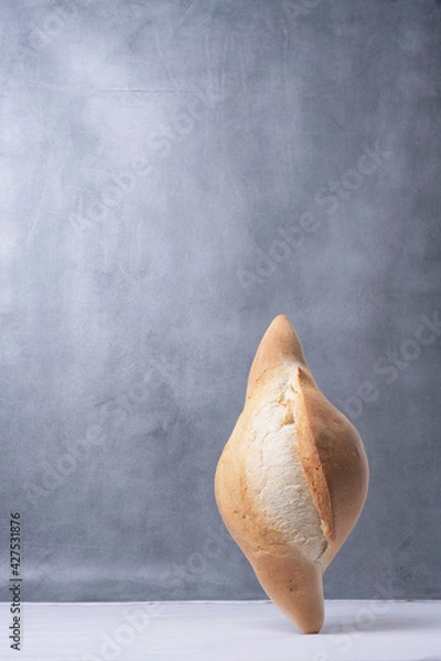 Obraz balancing bread on a table on a gray background