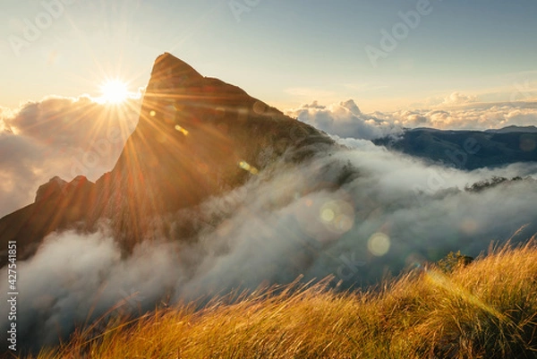 Fototapeta Munnar mountain landscape with flowing fog and clouds at sunrise