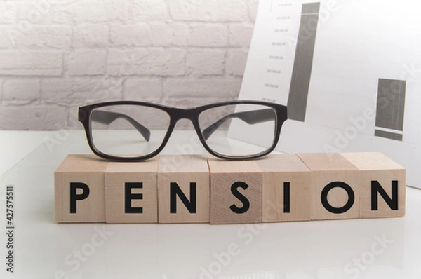 Fototapeta PENSION word about the concept of blocks standing on a white table surface, glasses on cubes