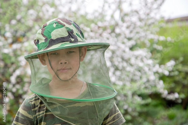 Obraz Boy in a hat with a mosquito net