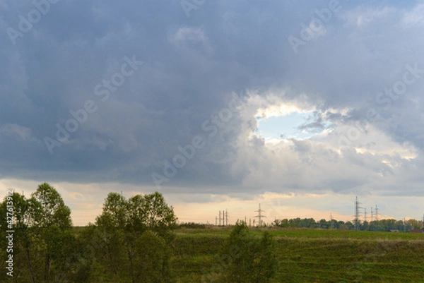 Fototapeta Landscape with a hole in the sky covered with clouds