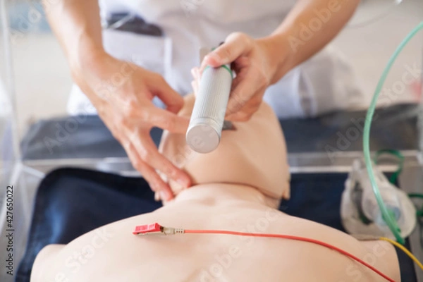 Obraz Blurred image of hands demonstrating process of endotracheal tube intubation to mannequin. Resuscitation process for acute respiratory failure, pneumonia, corona virus infection concept.