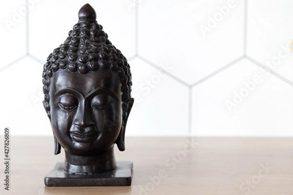Fototapeta Statuette head of buddha, space for text