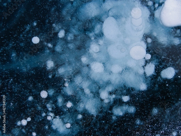 Fototapeta gas bubbles frozen in the ice of Lake Baikal form a picture similar to the starry sky. Siberia Russia