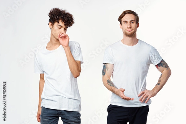 Fototapeta two men in white t-shirts stand side by side cropped view studio 