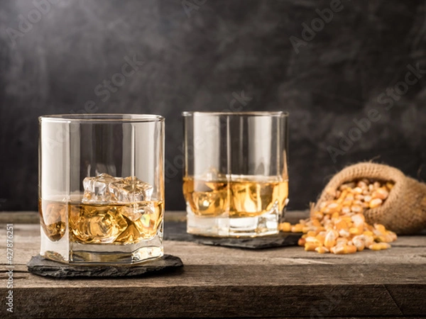Fototapeta A glass of classic corn whiskey (bourbon) on a wooden table. Copy space.