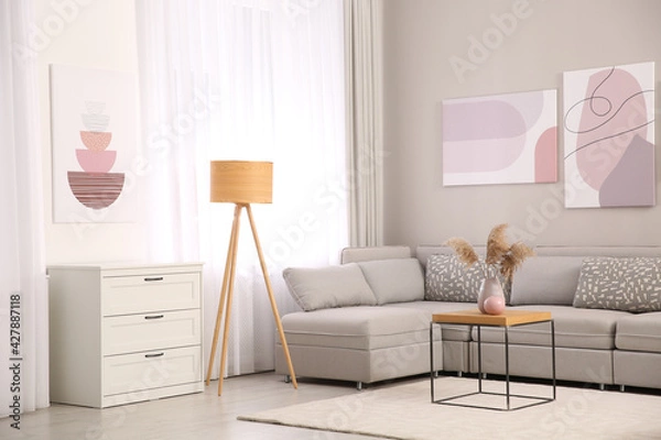 Fototapeta Stylish living room interior with big comfortable sofa and pictures