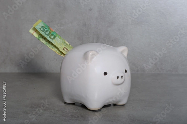Obraz Piggy bank from which a bill of five hundred Argentine pesos appears