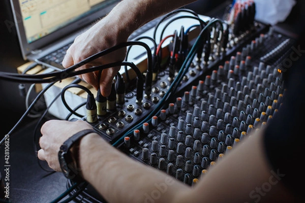 Fototapeta Sound engineer plugging jack audio cable on studio mixer.