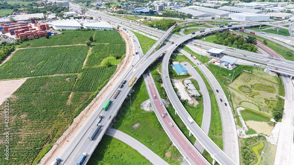 Fototapeta Aerial view of highway and overpass in city on a sunny day.