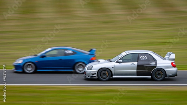 Fototapeta A panning shot of a racing car as it circuits a track.