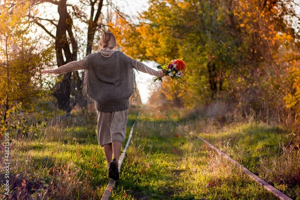 Obraz Girl with flowers in autumn on railway
