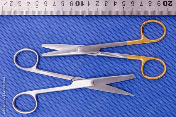 Fototapeta Operating (suture) scissors on a blue background