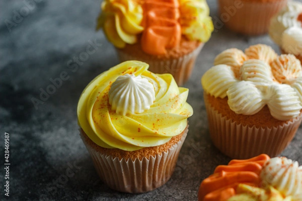 Obraz Delicious muffins. Orange and lemon cream muffins. Cupcakes on a concrete table 