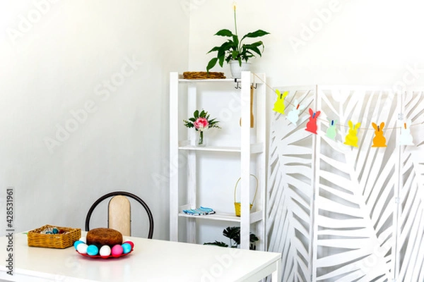 Fototapeta On the white table is an Easter cake and eggs