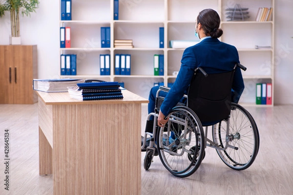 Fototapeta Young disabled employee during pandemic at workplace