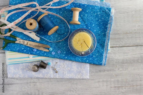 Obraz Blue fabrics  and sewing accessories for needlework.