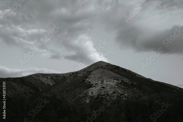 Fototapeta landscape with a hill top and clouds
