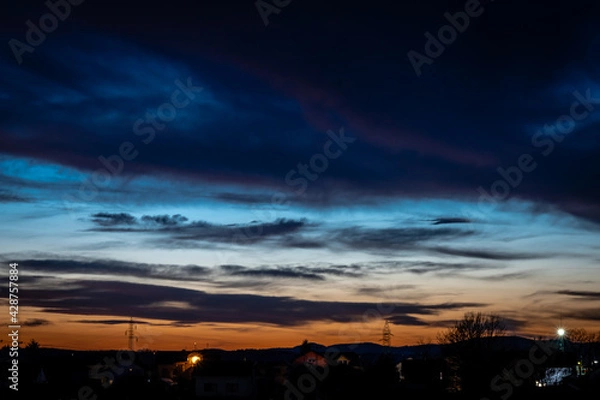 Fototapeta Sunset over the city with dramatic clouds