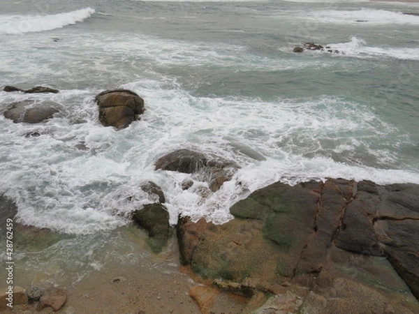 Fototapeta waves breaking on the rocks