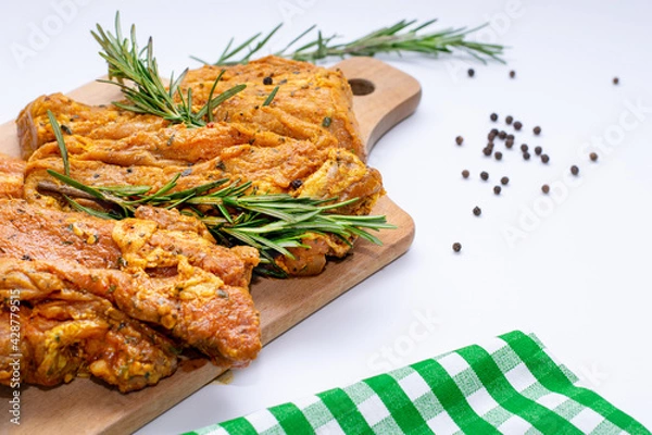 Obraz Raw marinated meat, steaks with rosemary and pepper on a white background