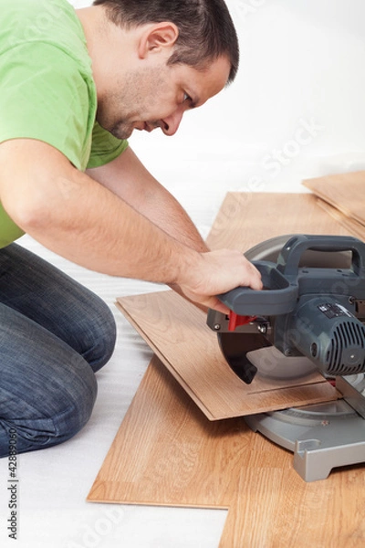 Obraz Cutting and laying laminate flooring planks