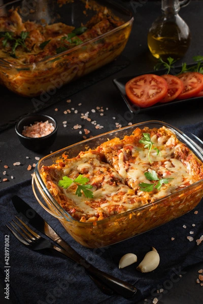 Obraz Tasty hot lasagna served on black background. Italian cuisine, menu, recipe. Homemade meat lasagna. Close up, side view.
