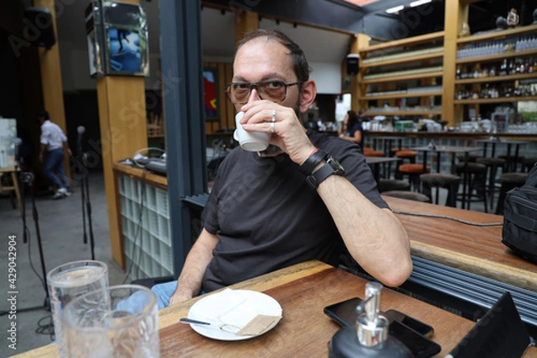 Obraz Matured man is drinking coffee in a bar.