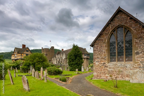 Fototapeta Medieval fortified manor of Stokesay Castle, showing the timber-framed gatehouse and the original castle, and in the foreground the church of St. John the Baptist and the graveyard: Shropshire, UK