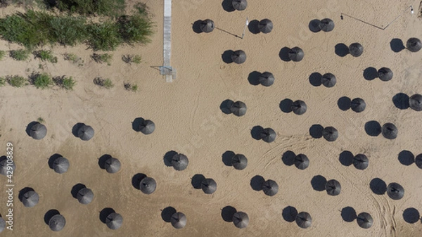 Fototapeta Top view straw umbrellas on the beach on a sunny day. The concept of rest and relaxation.