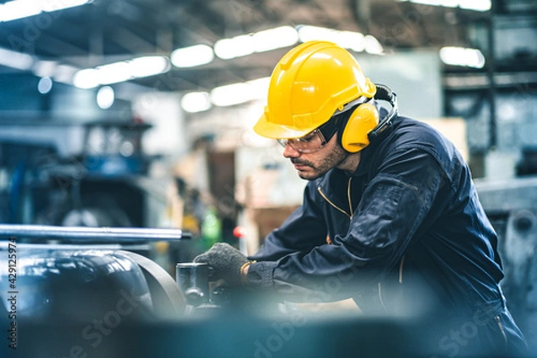 Fototapeta Industrial Engineers in Hard Hats.Work at the Heavy Industry Manufacturing Factory.industrial worker indoors in factory. man working in an industrial factory.Safety first concept.