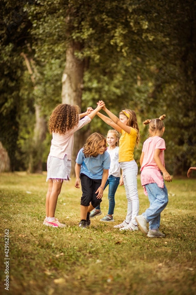 Fototapeta  Large group of school kids having fun in nature.