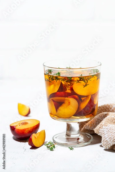 Fototapeta black tea with plum and thyme, vertical