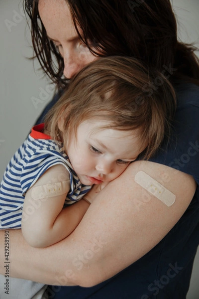 Fototapeta mother and daughter, a child after vaccination. A child with poor health and a high temperature.