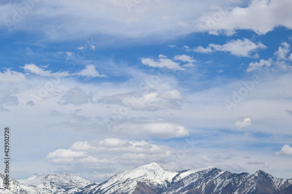 Obraz Mixed altocumulus clouds over snowy mountain