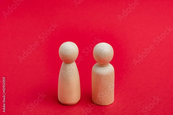 Fototapeta Wooden figurines of man and woman on red backdrop, relationship, communication problems. Happy couple concept