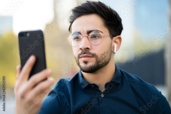 Obraz Young man using face id for unlock mobile phone outdoors.