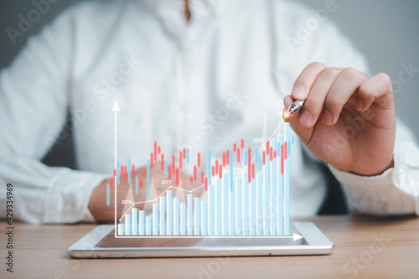 Fototapeta Businessman Analyzing business data in 2021, growth trends, next year's planning on virtual screen stock from the screen of digital tablet, development planning has a positive. Investment, finance.