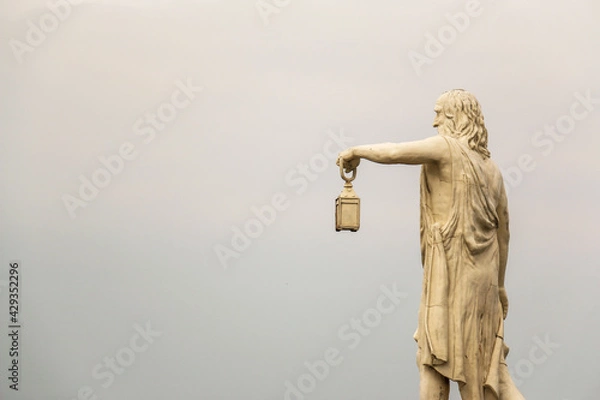 Fototapeta Famous ancient Greek philosopher Diogenes sculpture, holding light born in Sinop in the 5th century BC., with cloud backround.