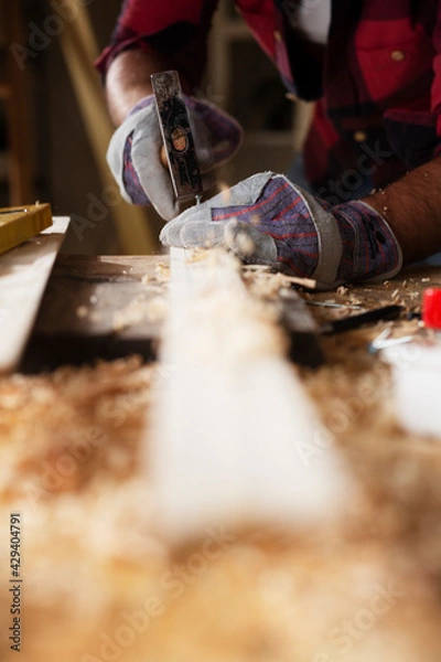 Fototapeta Close up of carpenter working in workshop. Carpenter working on wood craft at workshop.