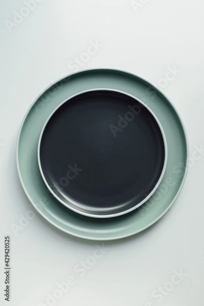 Obraz New luxury plate view from above on a isolated white background. Top view. Porcelain black and green saucer with white ring. Trendy pastel shades. Flat lay view.