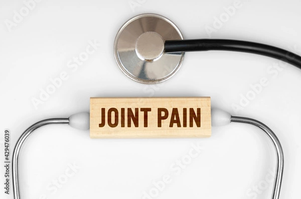 Fototapeta On the table is a stethoscope and a wooden plate with the inscription - JOINT PAIN