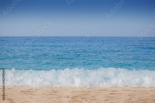 Obraz Closeup shoot of calm sea waves and foam on the sand beach.